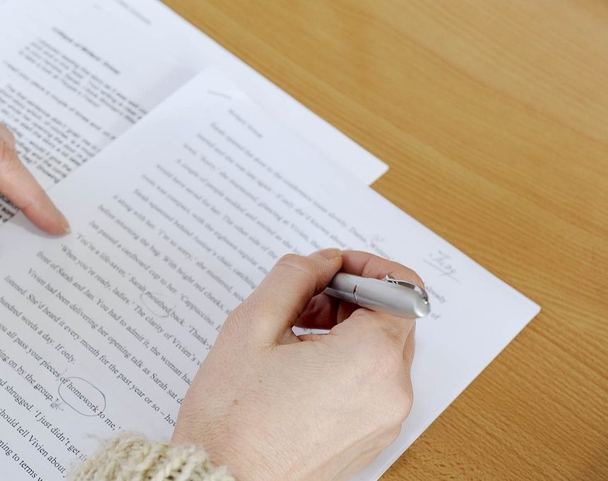hand holding pen, editing a printed page of text