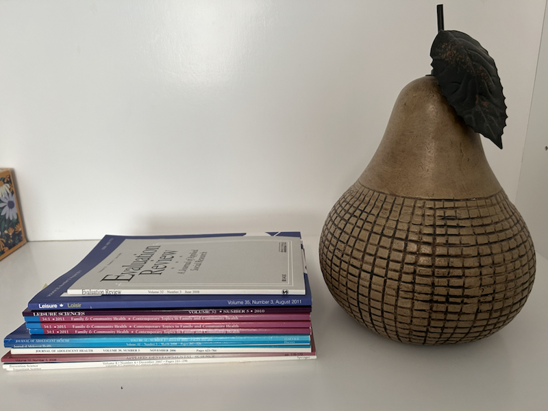 self with a stack of journals and a pear decoration